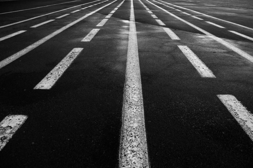 Grayscale image of a road with multiple perspective lines creating a dynamic visual effect.
